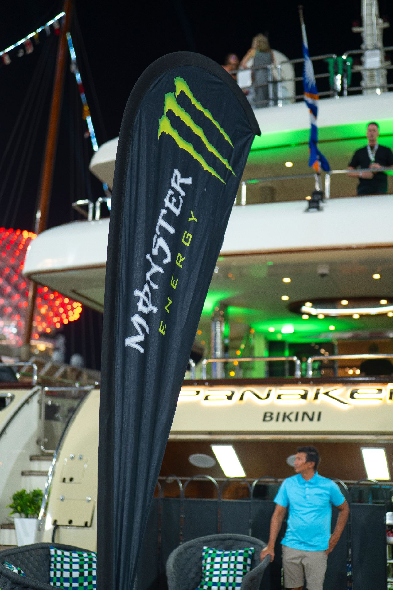 Monster Energy flag displayed beside the GP Management hospitality yacht at night